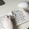 A person wipes down a SterileFLAT antibacterial standard keyboard
