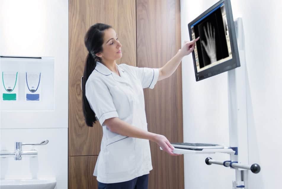 Nurse pointing at an Xray on a wall mounted monitor